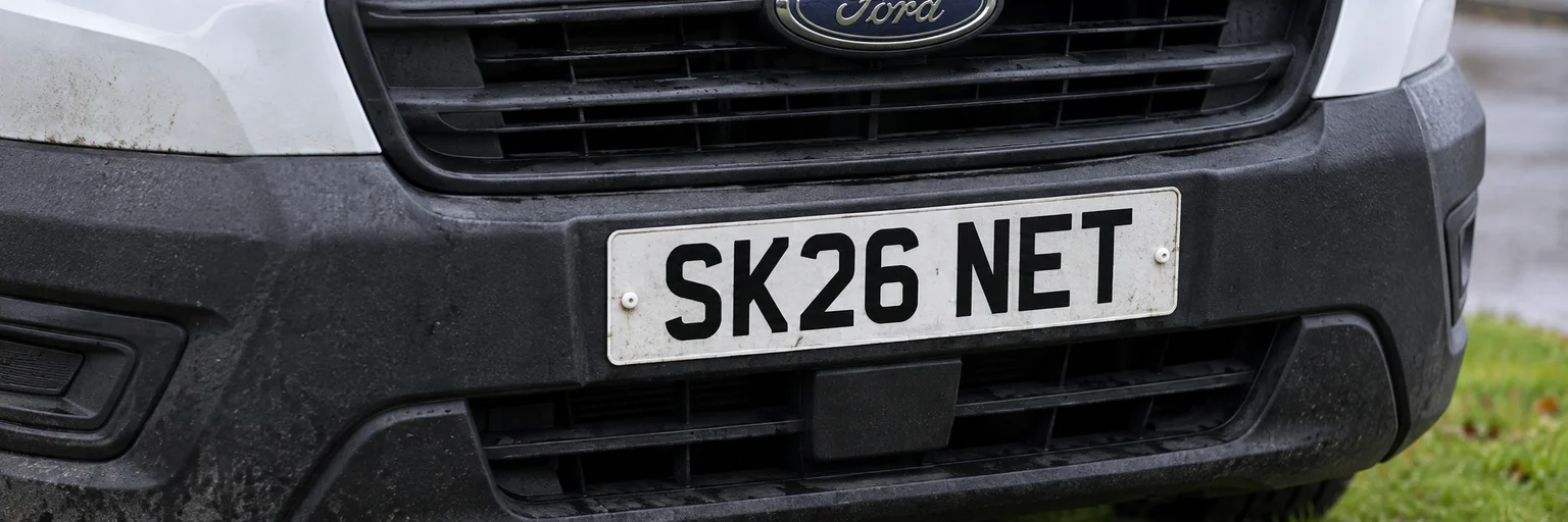 Close-up of the van’s front number plate: SK26 NET.