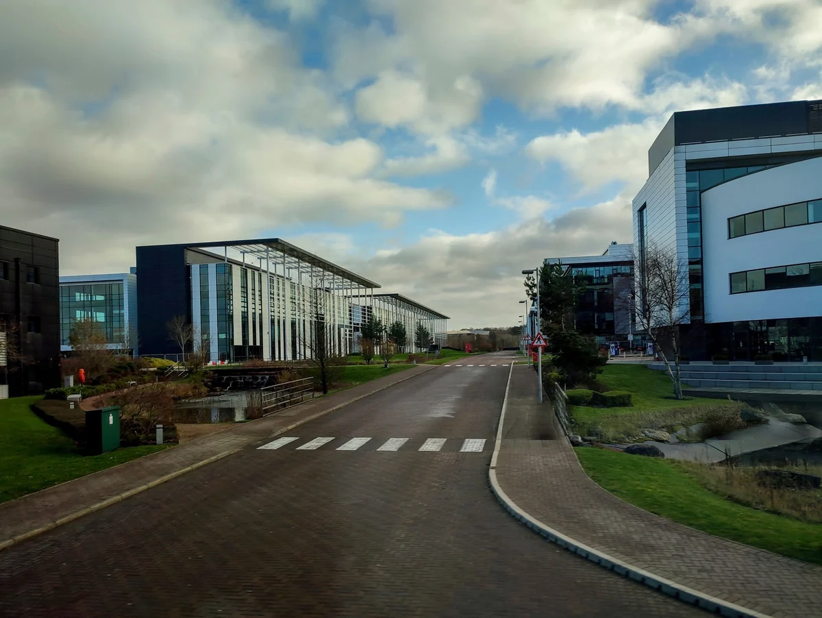 Office buildings, landscaped grounds and shared roads across a business park.